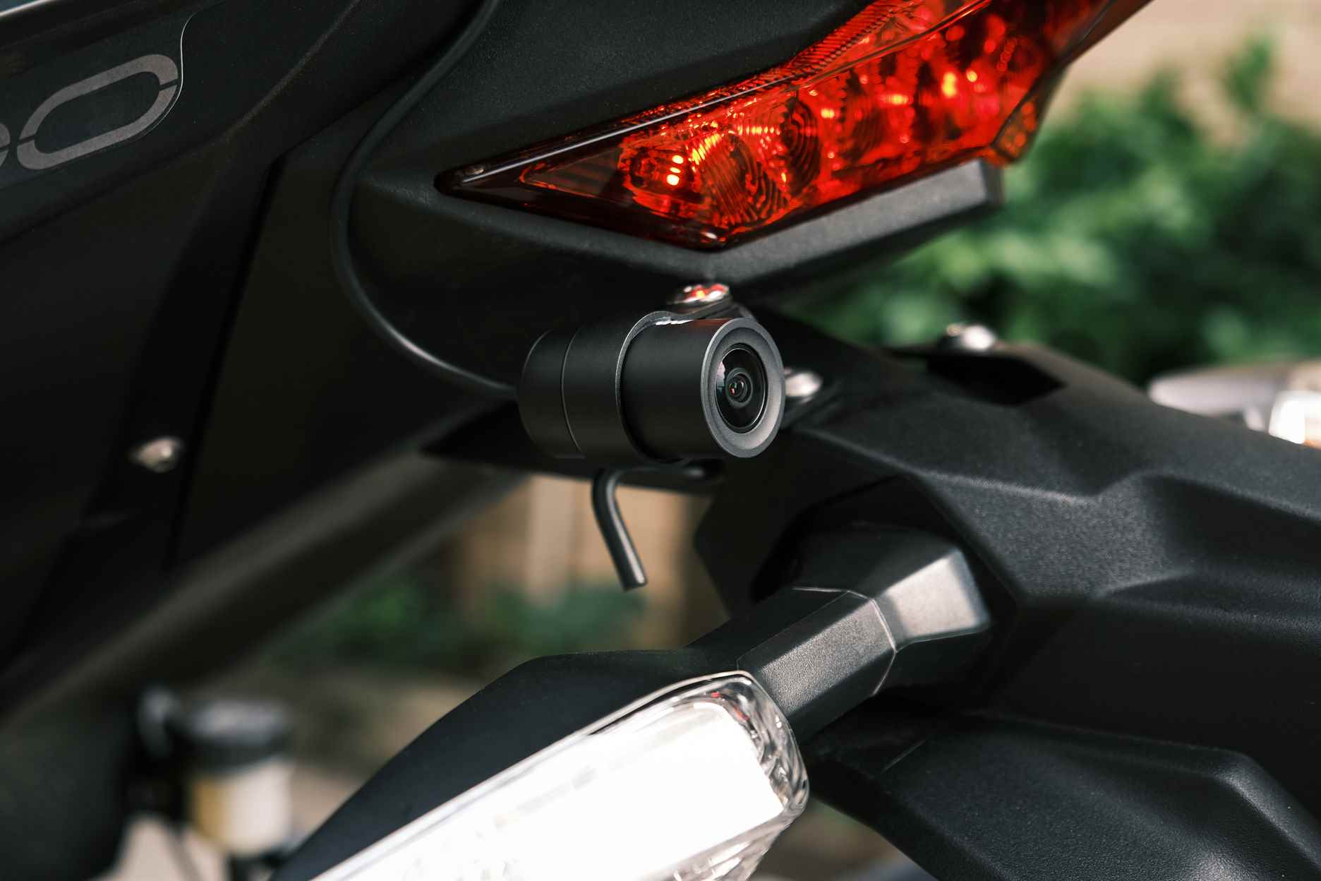 Close-up of a motorcycle's rear with a focus on the taillight and a mounted action camera.